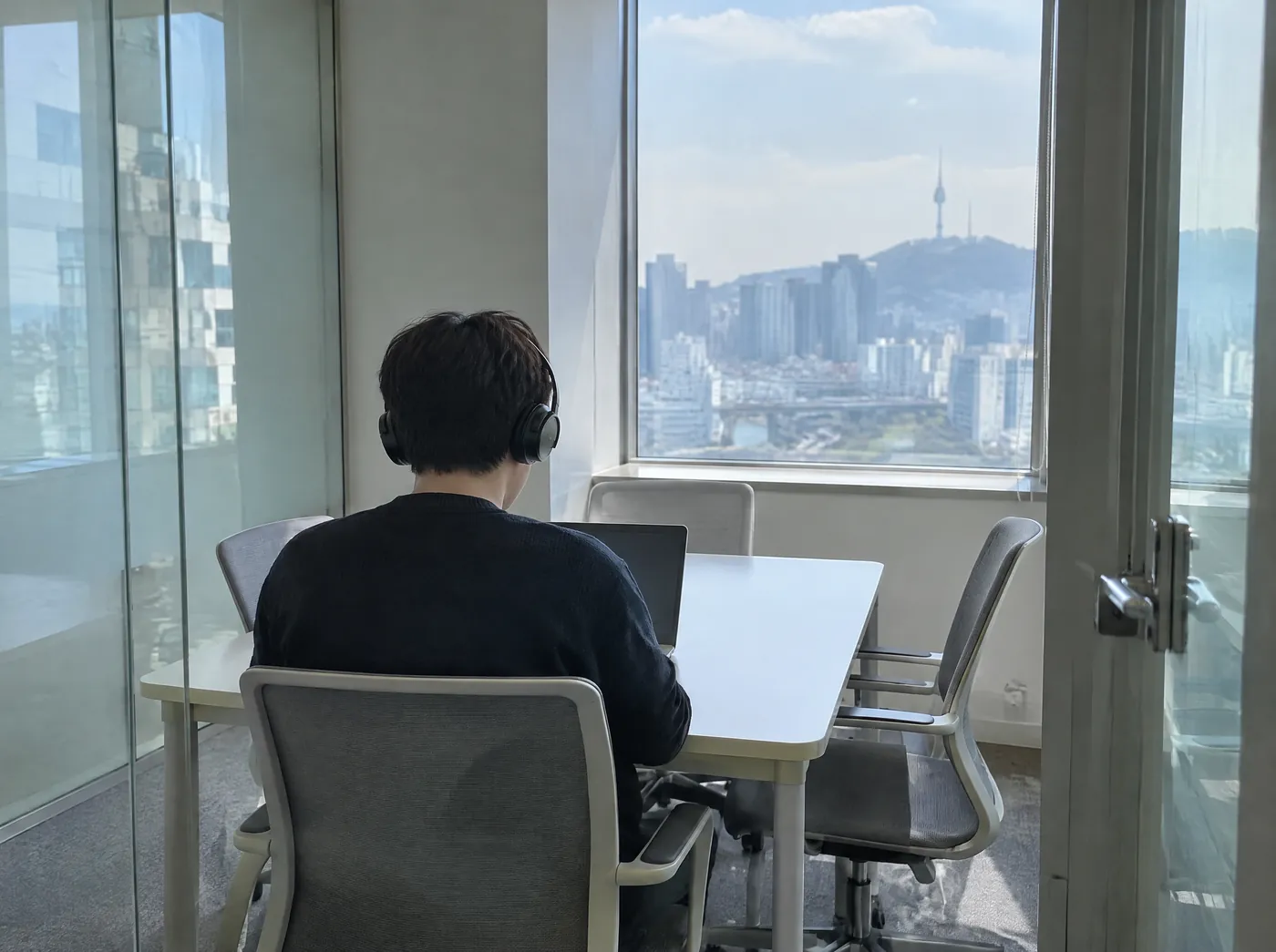 점심시간 비어 있는 작은 회의실에서 헤드셋을 쓰고 노트북 앞에 앉은 뒷모습